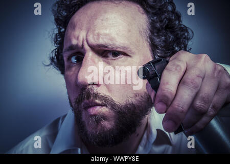 Reinigungsspray, Mann mit intensiven Ausdruck, weißes Hemd Stockfoto