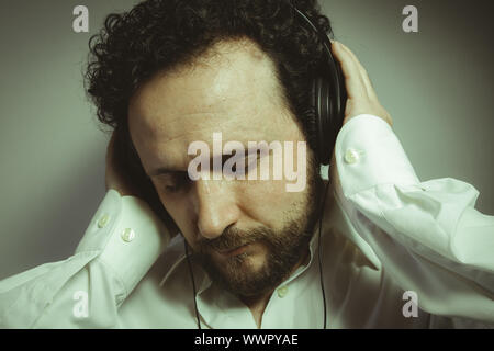 Genießen Sie die Musik, Mann mit intensiven Ausdruck, weißes Hemd Stockfoto