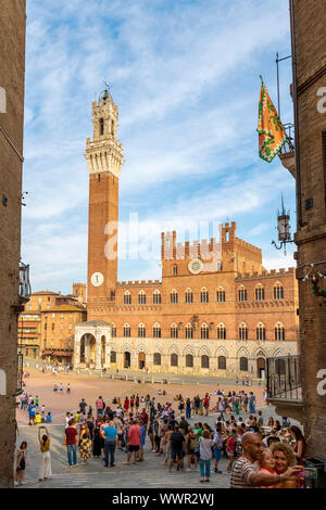 Siena, Italien - 1 September, 2019: Blick auf den Palazzo Pubblico und dem Torre del Mangia mit Blick auf die Piazza del Campo voller Touristen Stockfoto