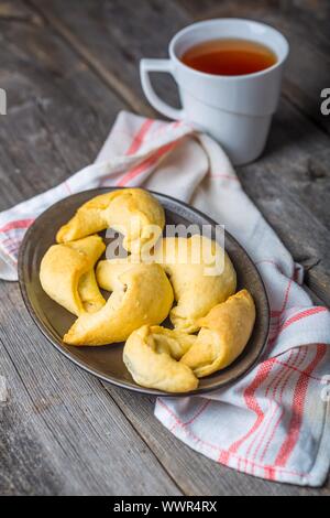 Hausgemachte Croissants und Tasse Tee auf Holztisch. Studio shot Stockfoto