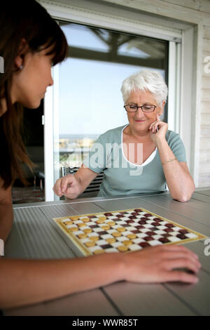 Junge Frau und senior Frau Dame spielen Stockfoto