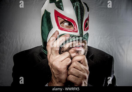 Wütend Geschäftsmann mit Maske des mexikanischen Kämpfer, gekleidet in Anzug und Krawatte Stockfoto