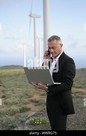 Geschäftsmann mit seinem Laptop und Telefon mitten in der Pampa Stockfoto