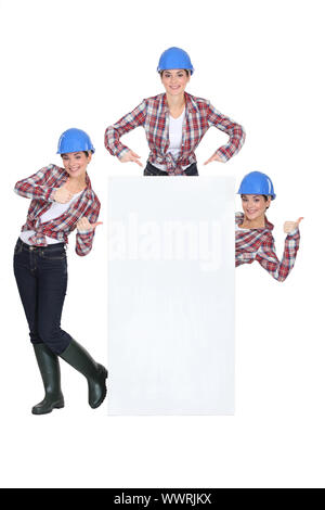 Weibliche Baumeister stand mit leeren poster Stockfoto