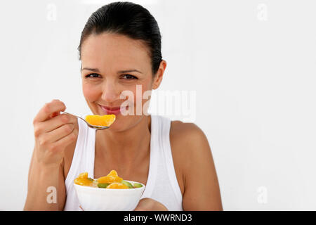 Frau, Essen eine Schale mit Obst Stockfoto