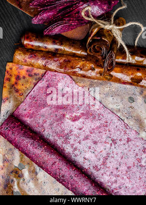 Obst pastille auf Holz- Hintergrund. Frucht Roll-ups von Himbeere, apfel, oplum gemacht, Johannisbeere, Erdbeere, gesunden Snack Konzept Stockfoto