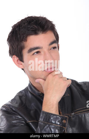 Junger Mann posiert in einem Leder-Biker-Jacke Stockfoto