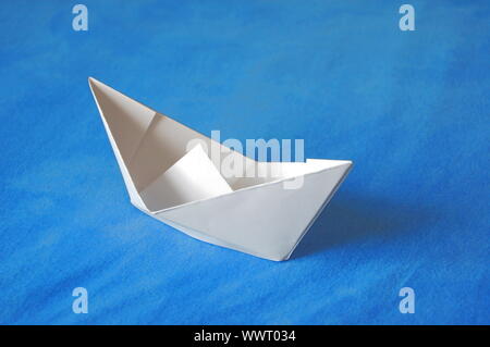 Origami Papier Boot auf blaues Wasser isoliert Stockfoto