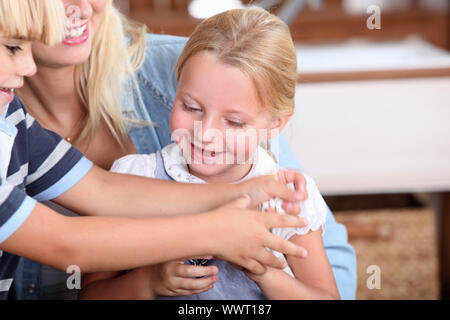 Kinder spielen mit Mutter Stockfoto