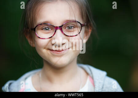 Glücklich lächelnde Kind Mädchen in Gläser. Selektive konzentrieren.