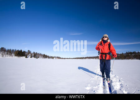 Eine Frau Langlaufen über einen zugefrorenen See Stockfoto