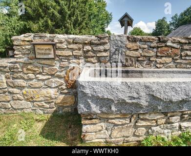 Berg Frühjahr Reines, klares, frisches Wasser mit Wasser Trog in Bergdorf tippen. Stockfoto