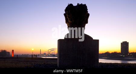 Skulptur Echo des Poseidon bei Sonnenuntergang, Skulptur Rhineorange im Hintergrund, Duisburg, Deutschland Stockfoto