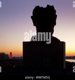 Skulptur Echo des Poseidon bei Sonnenuntergang, Skulptur Rhineorange im Hintergrund, Duisburg, Deutschland Stockfoto