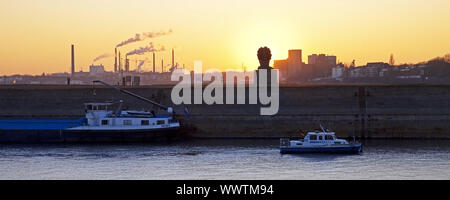 Skulptur Echo des Poseidon bei Sonnenuntergang mit Hafen Panorama, Duisburg, Ruhrgebiet, Deutschland, Europa Stockfoto