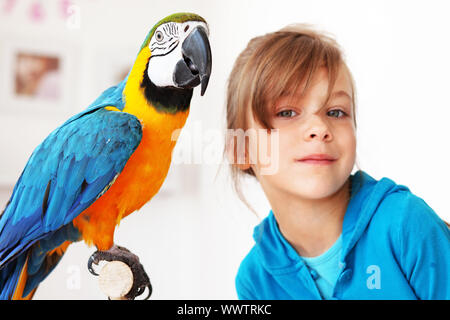 Porträt eines Mädchens Kind mit ihrem inländischen Ara Papagei Stockfoto