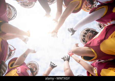 Foto von unten der Mannschaft des American Football Spieler gegen den blauen Himmel am Nachmittag Stockfoto