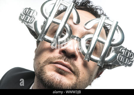 Gewinn, Geschäftsmann mit Anzug und Brille in Form von Dollar. Ausdruck von Stress, Überforderung und das Verlangen nach Geld Stockfoto