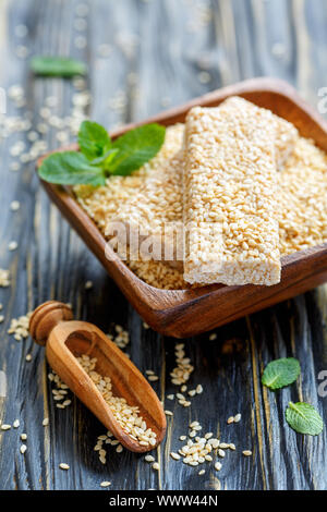 Bars mit Sesam in Honig glasieren und eine Schaufel mit Sesam. Stockfoto