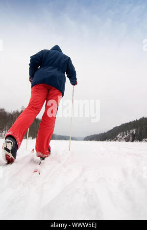 Ein cross country Skier heraus auf eine erfrischende Reise über einen zugefrorenen See. Stockfoto