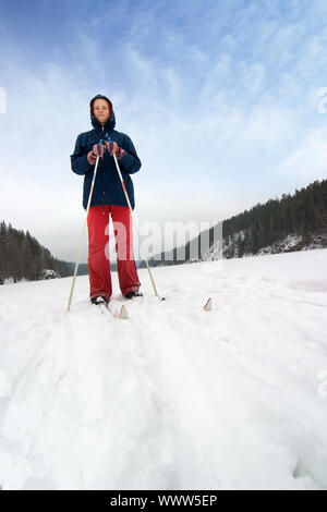 Eine Langlaufloipe, Ski-fahrer auf eine erfrischende Reise über einen zugefrorenen See. Stockfoto