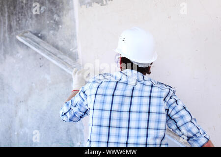 Arbeiter richtet Wand für die Leitung Stockfoto