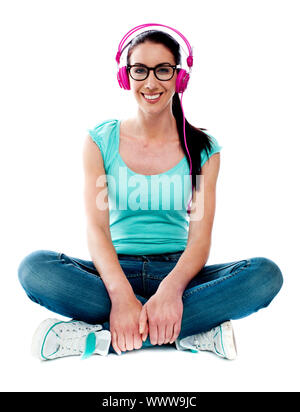 Teenager auf Boden sitzen und Musik hören. Alle auf weißem Hintergrund Stockfoto