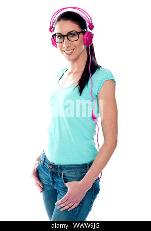 Hübsches Mädchen anhören von Musik über Kopfhörer, isoliert auf weiss Stockfoto