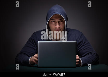 Junger Mann mit einem Hoodie sitzen vor einem Laptop. Stockfoto