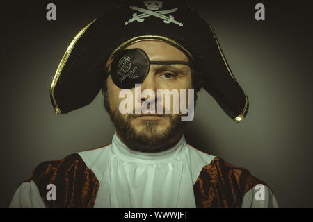 Buccaneer, Mann mit Bart, gekleidet wie ein Pirat mit Augenklappe und Stahl Schwert Stockfoto