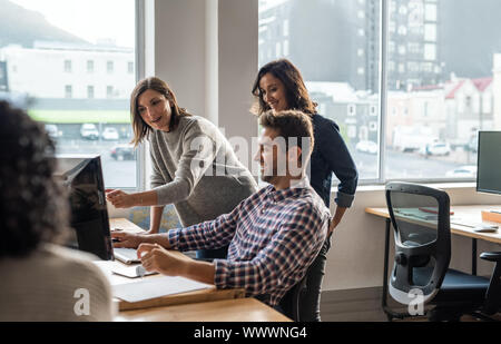 Gruppe von jungen Designern, die Computer gemeinsam Stockfoto