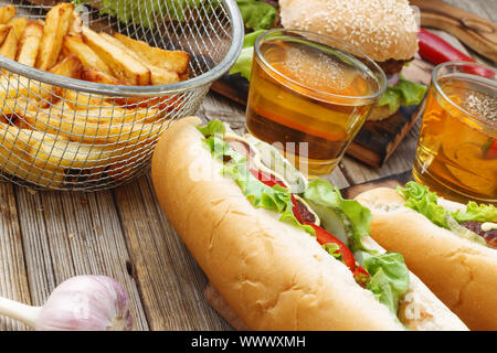 Hot Dogs, verschiedene Snacks und Bier auf einem Holztisch, close-up. Nationalen Tag hot dog USA Stockfoto