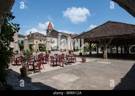 Malerische Aussicht von Monpazier Hauptplatz, mit der Holz- Halle und Cafe Sitzplätze Stockfoto