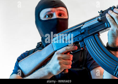 Dieb, bewaffneter Mann mit Sturmhaube und kugelsichere Weste, Pistole und Schrotflinte, kalaschnikow Stockfoto