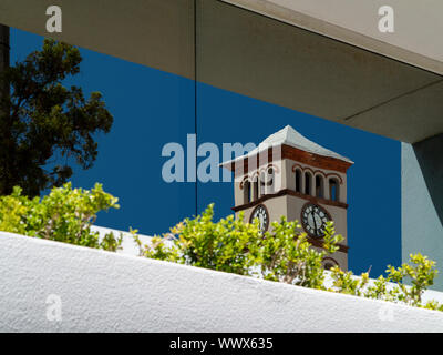 Die Spitze des Uhrturms der Sessions House Church St, Hamilton, Bermuda spiegelt sich in einem Glasfenster gegenüber Stockfoto