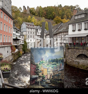 Staffelei mit Bild vor und die fachwerkhäuser an der Rur, Monschau, Eifel, Deutschland, Europa Stockfoto