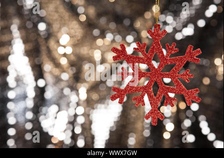 Red snow flake auf einer gold glitzer Hintergrund Stockfoto