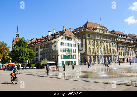 Bern, Schweiz - 14 August 2019: Bundesplatz, den Platz im Zentrum der Schweizer Hauptstadt mit Menschen zu Fuß. Historische Gebäude, Cafes, Restaurants. Wasserfontänen. Sommertag. Stockfoto