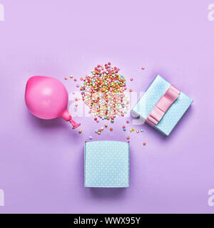 Blauen Geschenkbox mit verschiedenen Konfetti, Ballons, Dekorationen auf grünem Hintergrund. Bunte h Stockfoto