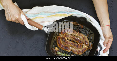 Hausgemachte Bratwurst durch Frau in Händen serviert. Stockfoto