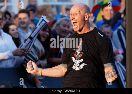 Tenby, Großbritannien. 15 Sep, 2019. Im Bild: Gareth Thomas feiert, als er die Ziellinie überquert. Sonntag, 15 September 2019 Re: Ironman Triathlon Veranstaltung in Tenby, Wales, UK. Credit: ATHENA PICTURE AGENCY LTD/Alamy leben Nachrichten Stockfoto