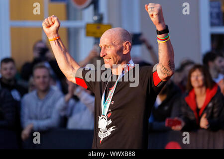 Tenby, Großbritannien. 15 Sep, 2019. Im Bild: Gareth Thomas feiert, als er die Ziellinie überquert. Sonntag, 15 September 2019 Re: Ironman Triathlon Veranstaltung in Tenby, Wales, UK. Credit: ATHENA PICTURE AGENCY LTD/Alamy leben Nachrichten Stockfoto