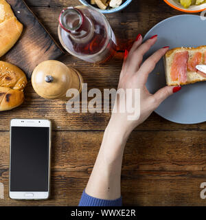 Frau, die ein Sandwich mit Lachs und Butter. Stockfoto