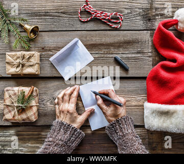 Konzeption: Weihnachten. Ein Mann schreibt einen Brief an den Weihnachtsmann Stockfoto