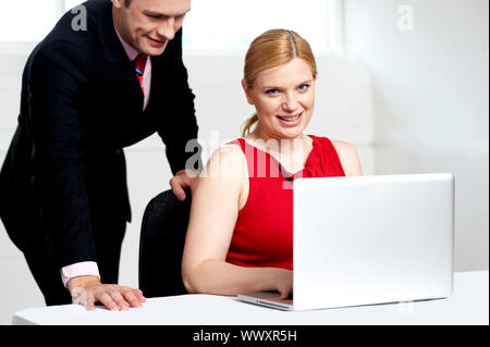 Trendige Chefin arbeiten am Laptop mit Mann Unterstützung Stockfoto