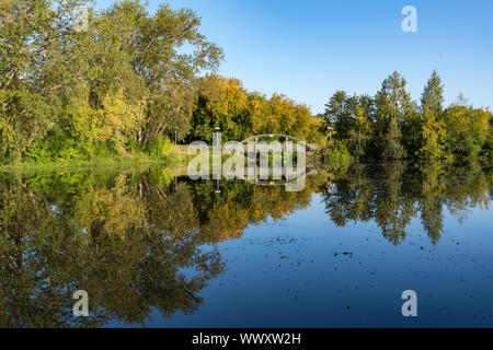 Zakharyevsky Park, eine Brücke über den Tabora Teich, neben Tichwin Annahme (Bogorodichny Uspensky) Kloster. Region Leningrad. Russland Stockfoto