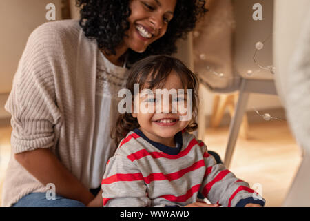 Kleine Mädchen spielen mit ihrer Mutter in eine Decke fort Stockfoto