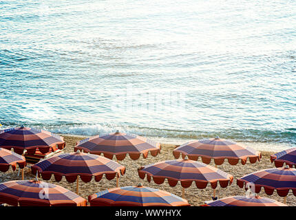 Sonnenschirme öffnen früh am Morgen am Strand am Meer. Strand Urlaub während der Sommersaison. Stockfoto