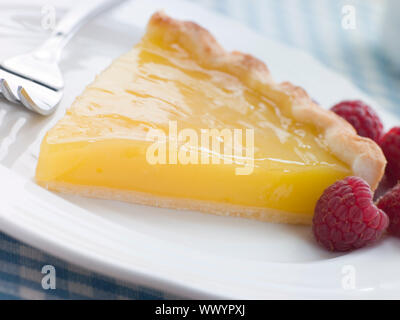 Slice Zitronencreme Tarte mit englischen Himbeeren Stockfoto