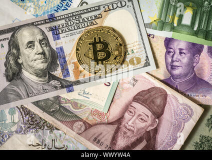 Golden bitcoin über multi Banknoten der Dollar, Yuan, Euro Stockfoto